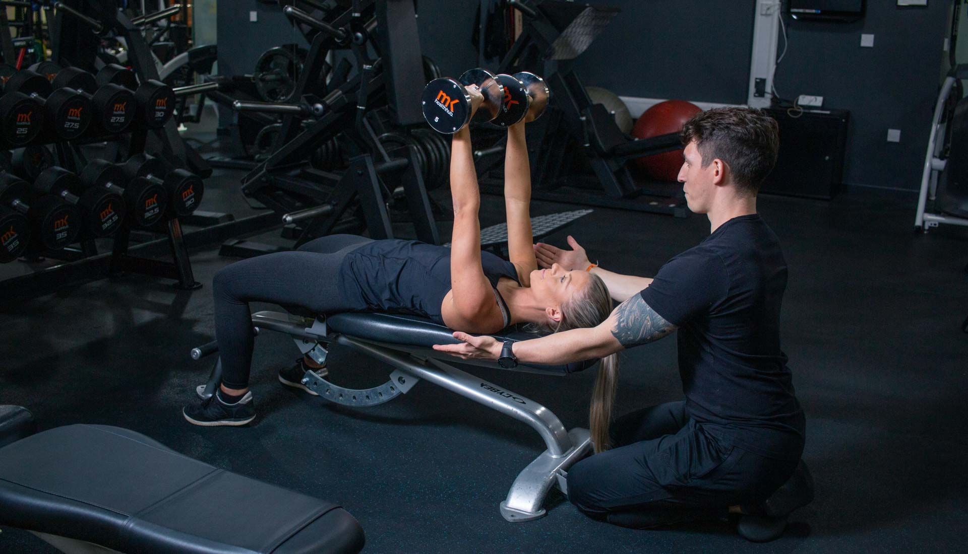 Personal traner helping a client exercise. Fitness photography Birmingham UK, professional gym photography Birmingham and West Midlands UK