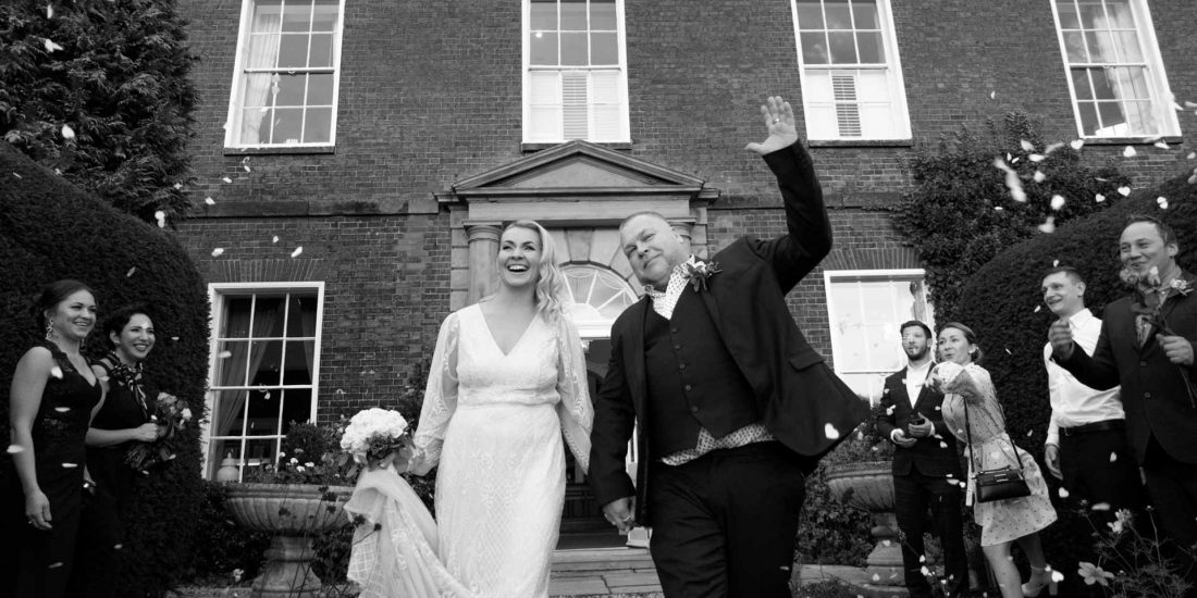 wedding confetti exit. Bride and groom walking through confetti in Dovercliff Hall Hotel