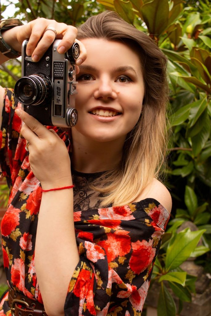 Photographer Anastasia Jobson is holding FED 5 film camera ready to take a photo. How to use tiktok as a photographer 