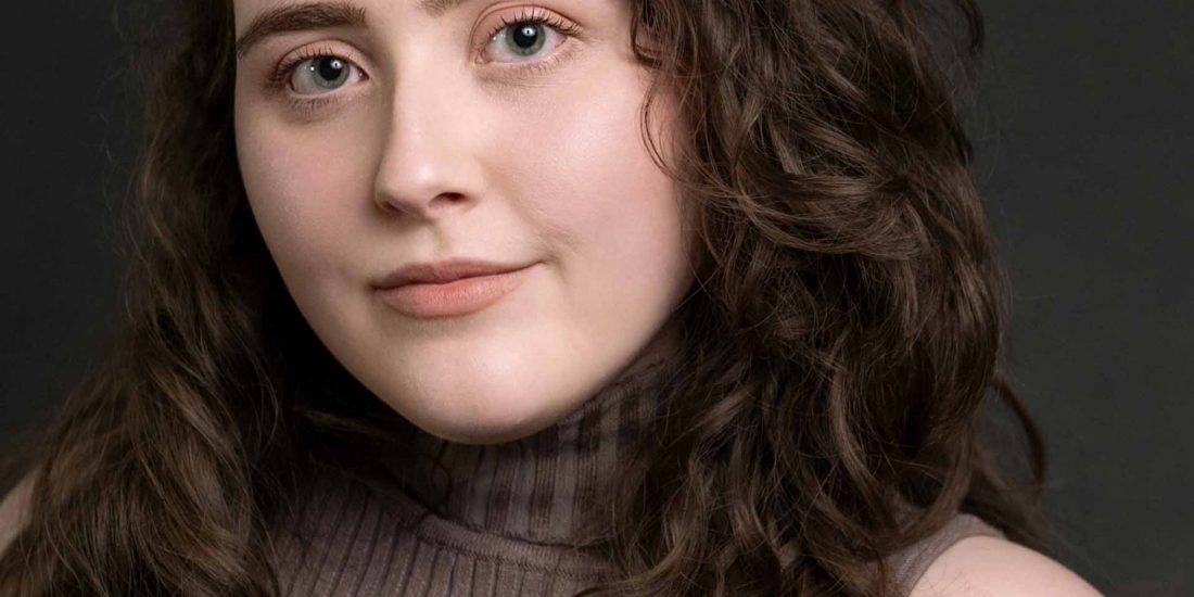 Studio headshot of a Birmingham female actor dark background