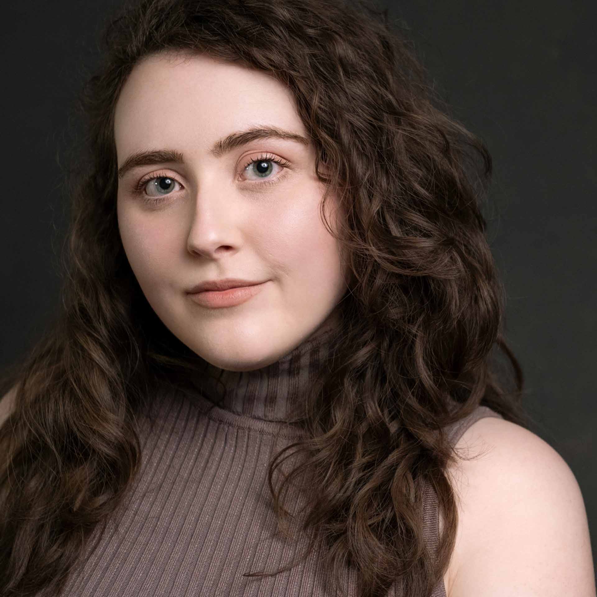 Studio headshot of a Birmingham female actor dark background