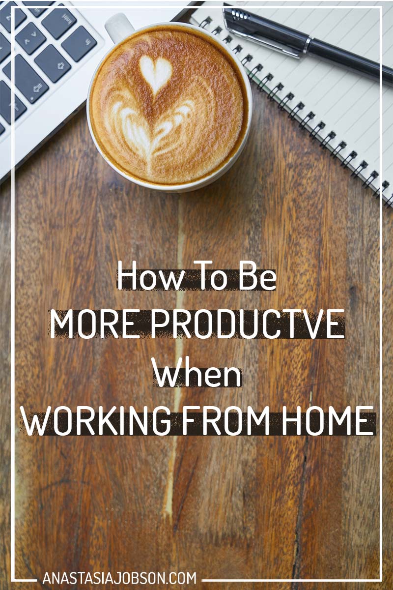 Wooden table with laptop, notepad, and a cup of white coffee with a heart-shape foam art and text saying how to be more productive when working from home