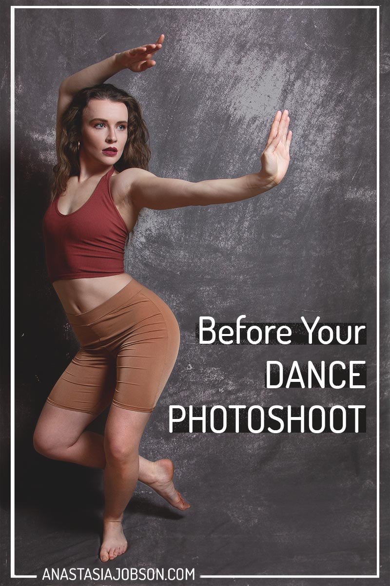 A dancer with long brown hair, wearing red top and beige shorts is striking a dance pose