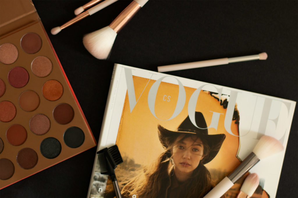 a flatlay photography to improve your photography from home, with CZ vogue magazine, makeup brushes, eyeshadow palette  