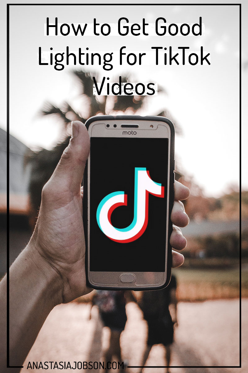 Man's hand holding phone with TikTok icon on. How to get good lighting for your TikTok videos