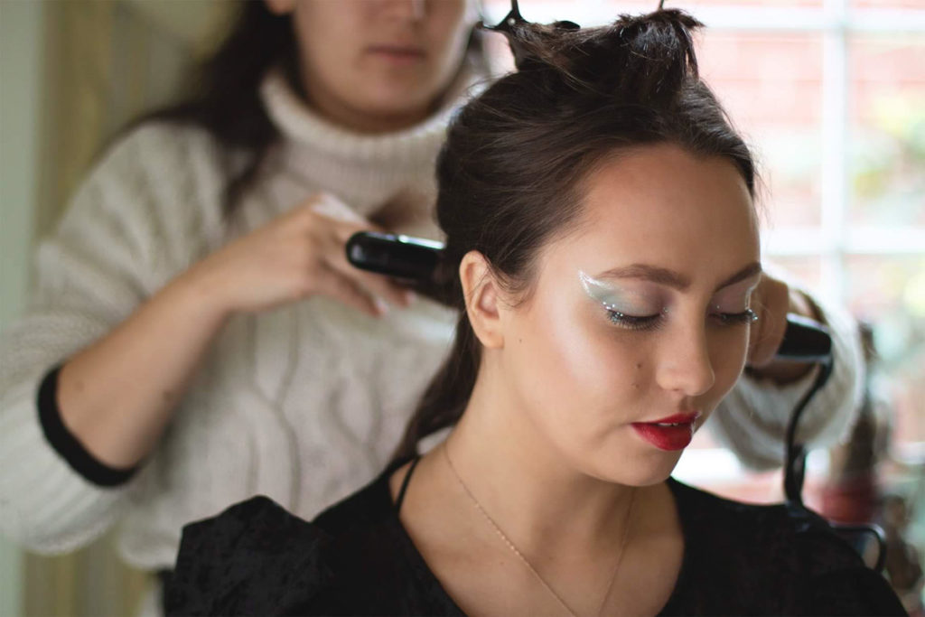 A woman is having her hair done for a photoshoot. Make up and hair by Eleonora Manzi, Photo by Anastasia Jobson