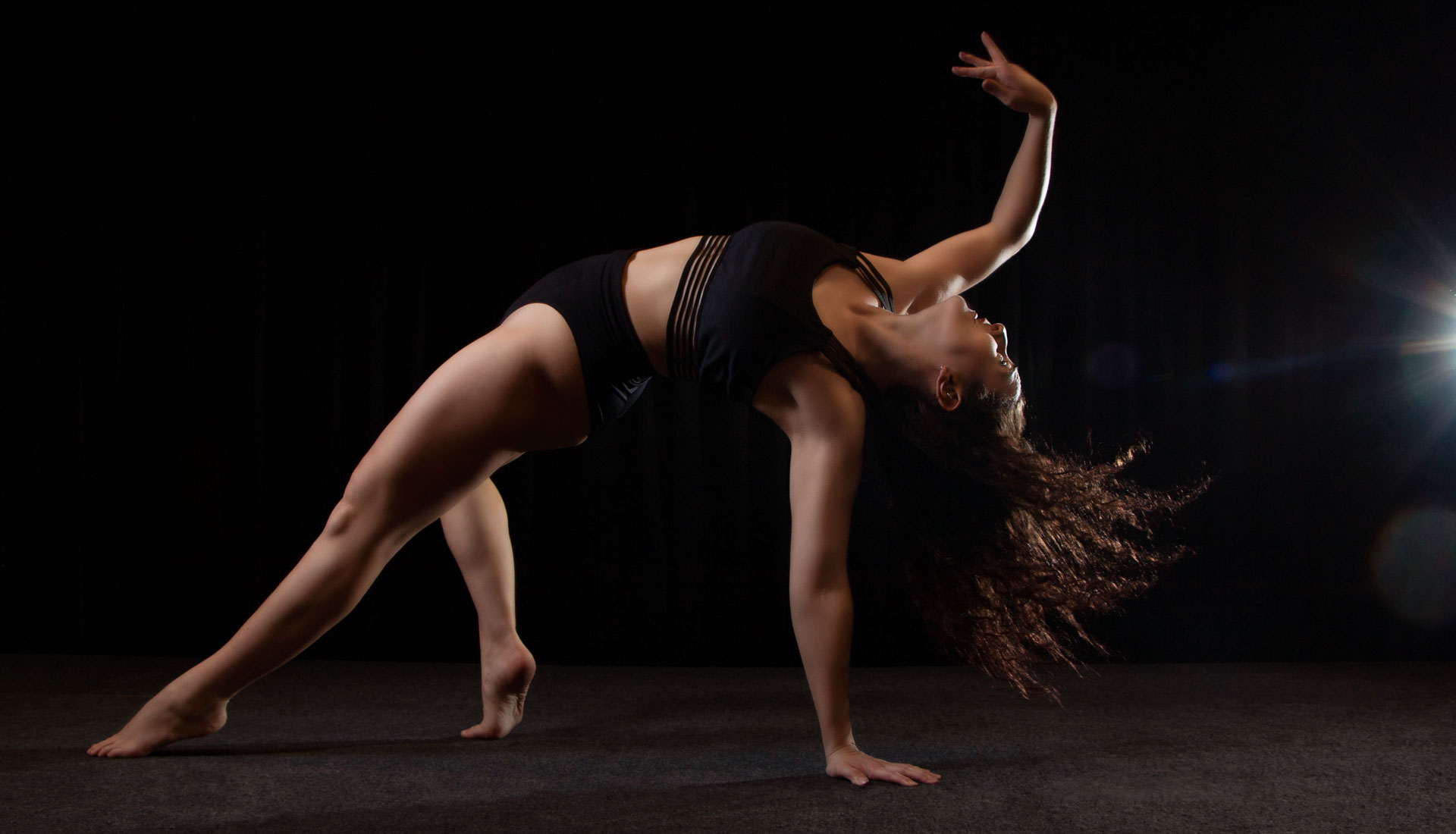 Female dancer wearing black crop top and shorts in motion. Dance and performance portfolios in West Midlands