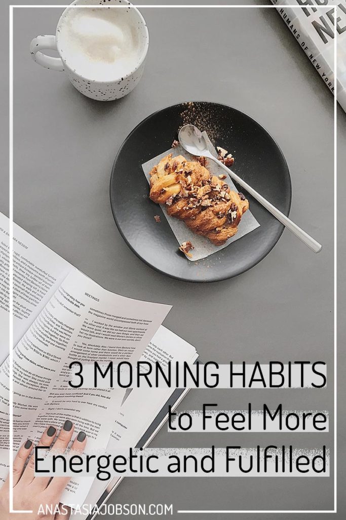 A dark grey plate with a pastry on a light grey table and woman's hand flicking through a book. Text saying 3 morning habits to feel more energetic and fulfilled