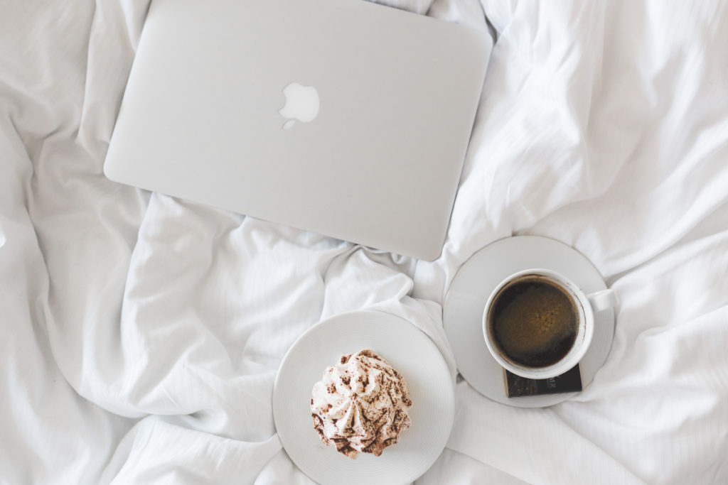 3 morning habits, breakfast in bed with a cup of black coffee and desert on white bedsheet