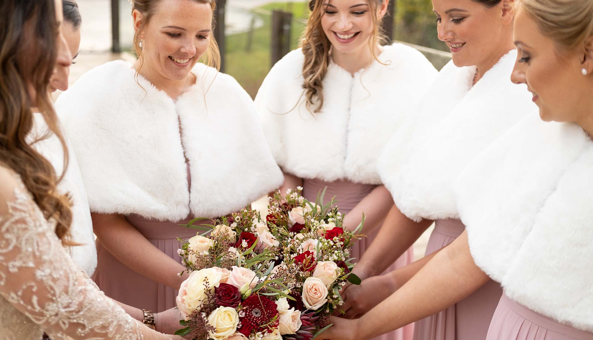 Bride and bridesmaids posing with bouquets for a photo at Mill Barns