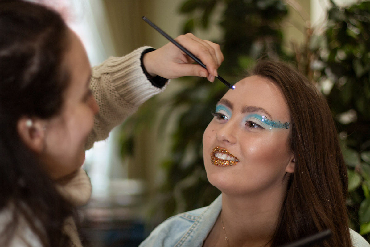 Backstage from a beauty editorial photoshoot. A makeup artist applying makeup on model's face. Makeup tips every photographer should know. 