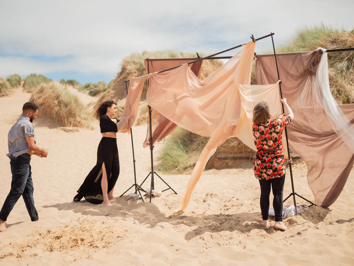 Building a fabric backdrop on teh beach for music video filming