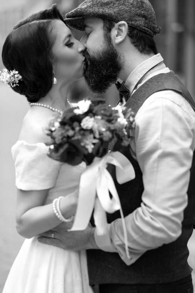 Bride and groom having their first kiss at their wedding day