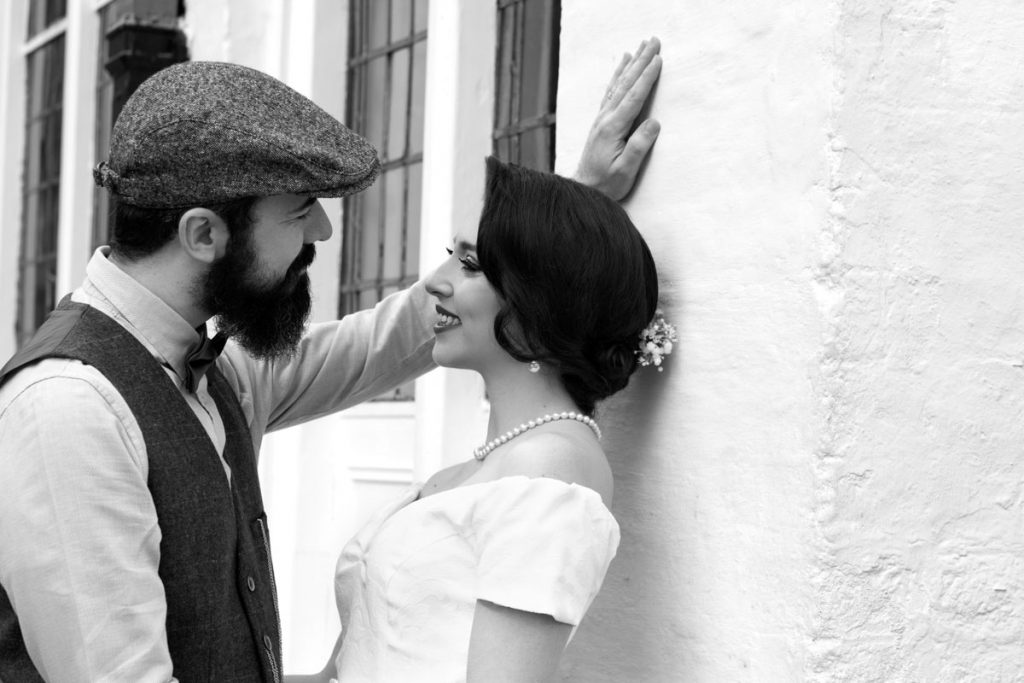 Bride and groom talking by the wall. Retro wedding photography session in Digbeth, Birmingham.