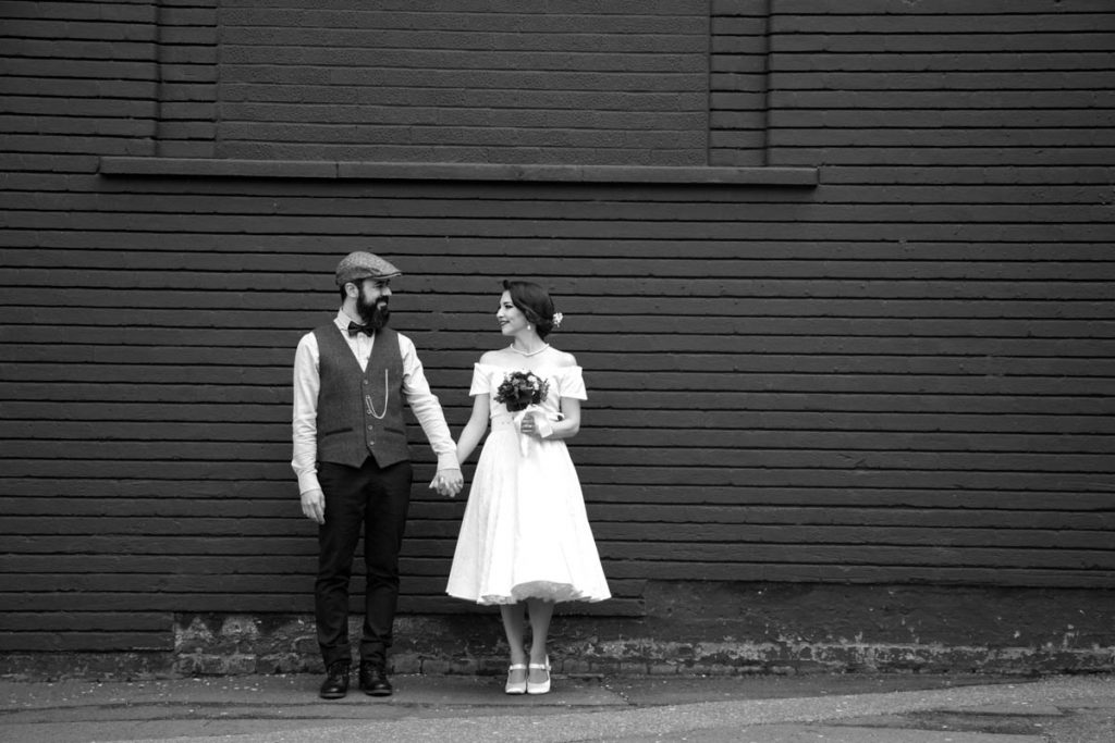 Bride and groom holding hands and looking at each other during a wedding photography session in Birmingham city centre