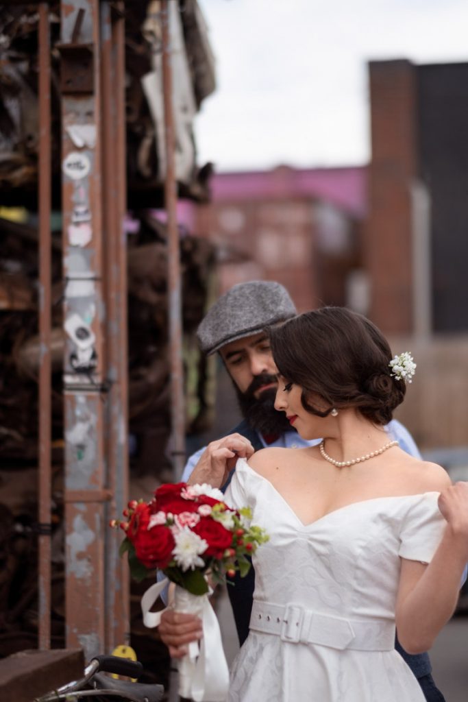 Groom putting a coat on hos bride's shoulders