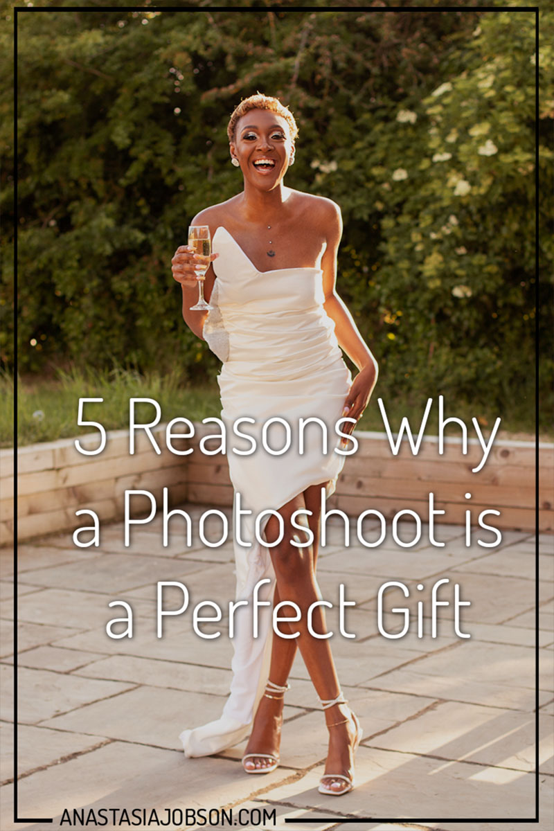 Woman in a white dress holding champagne laughing. reasons why a photoshoot is a perfect gift