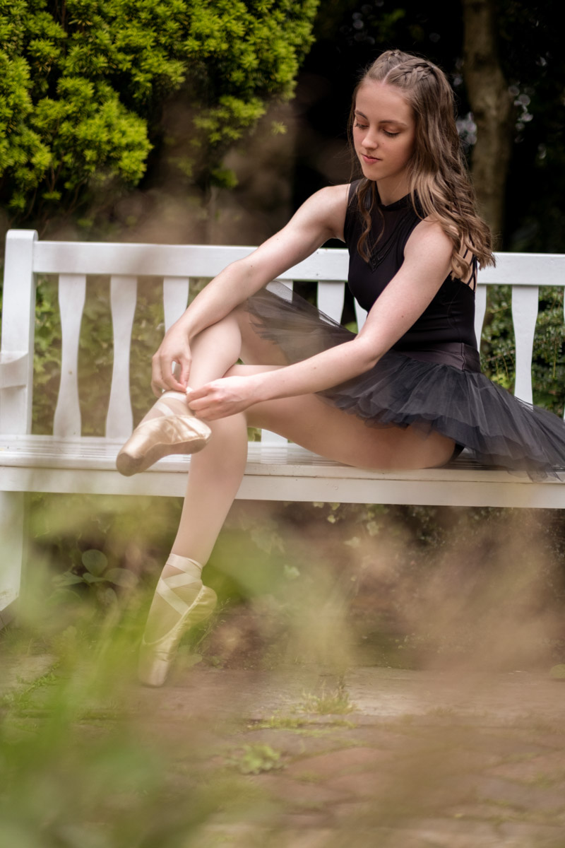 Ballerina putting on pointe shoes, outdoor dance photoshoot in birmingham