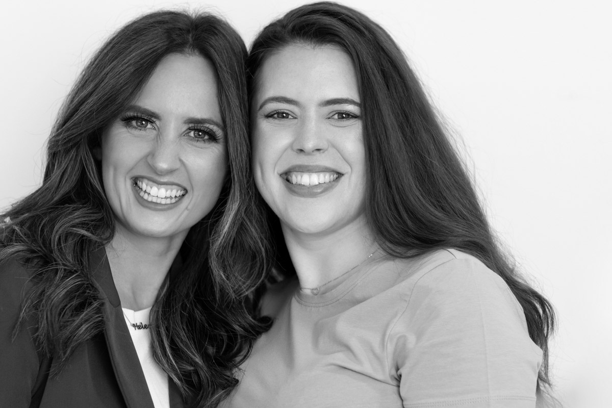 a group headshot portrait of two female business owners laughing