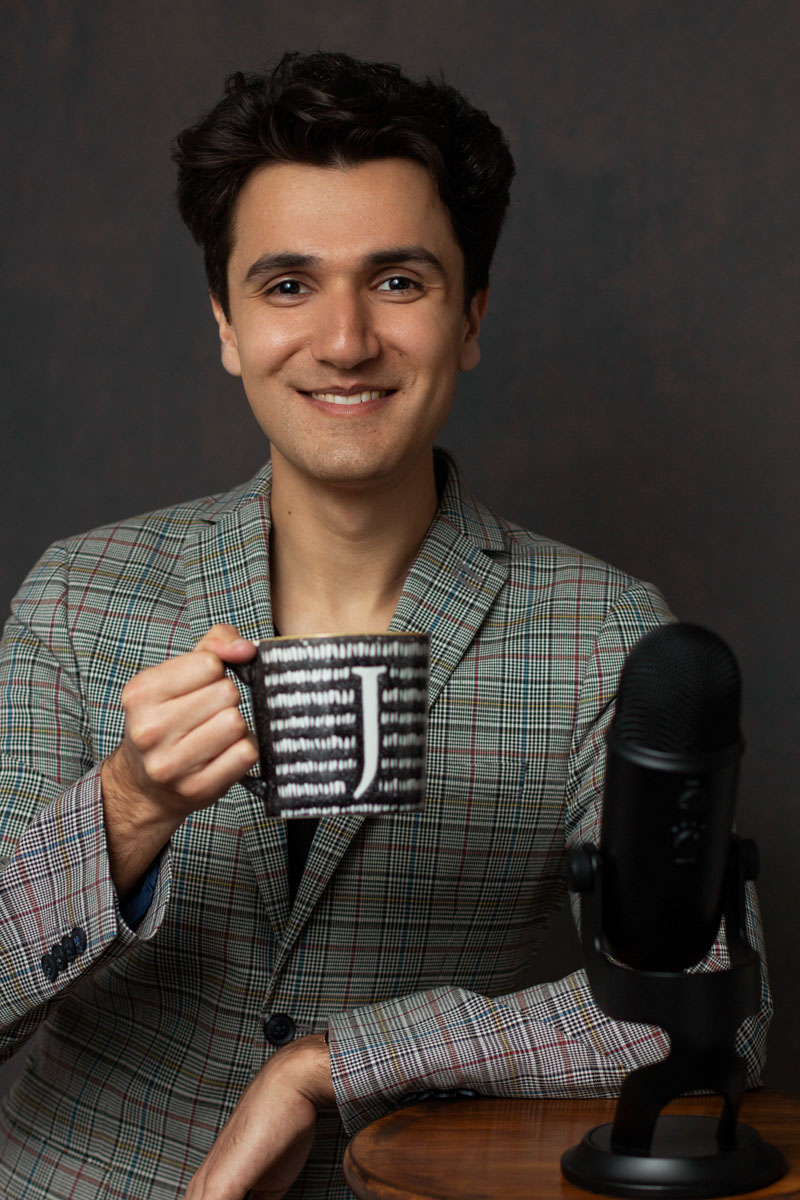 creative headshot example of a man with a cup of tea and a podcast microphone