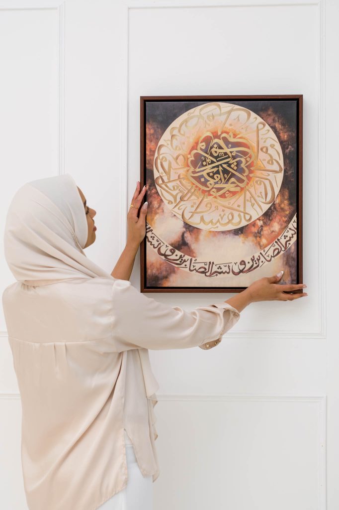 artist is hanging her artwork on the wall, artist branding photoshoot