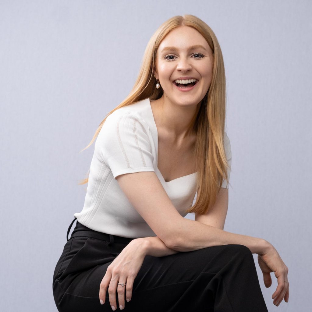 smiling business woman portrait in front of white wall