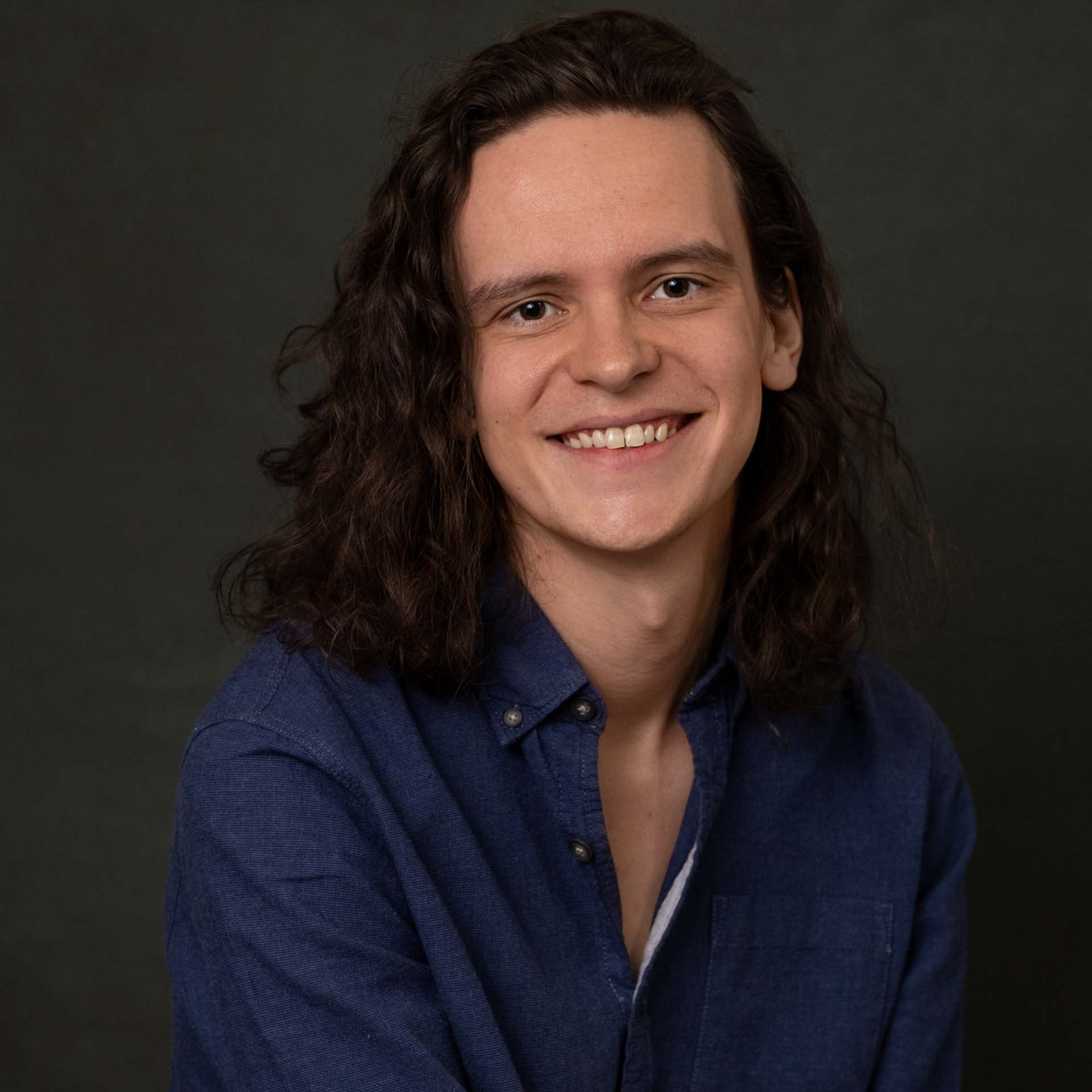 Professional photo headshot smiling, dark background