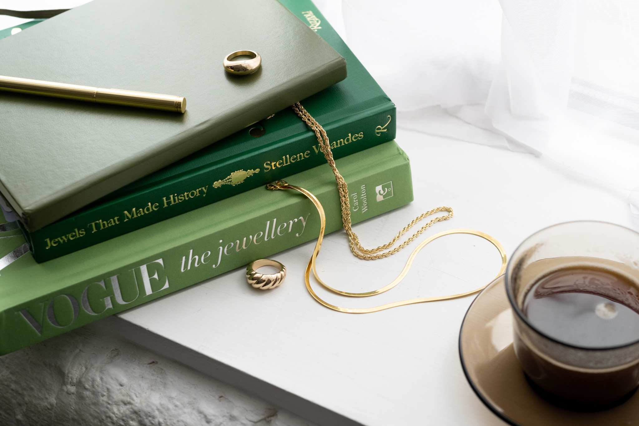 Content Ideas for service-based businesses: Branding photography for jewellery copywriter. Books about jewellery with golden rings and chains, and coffee.  