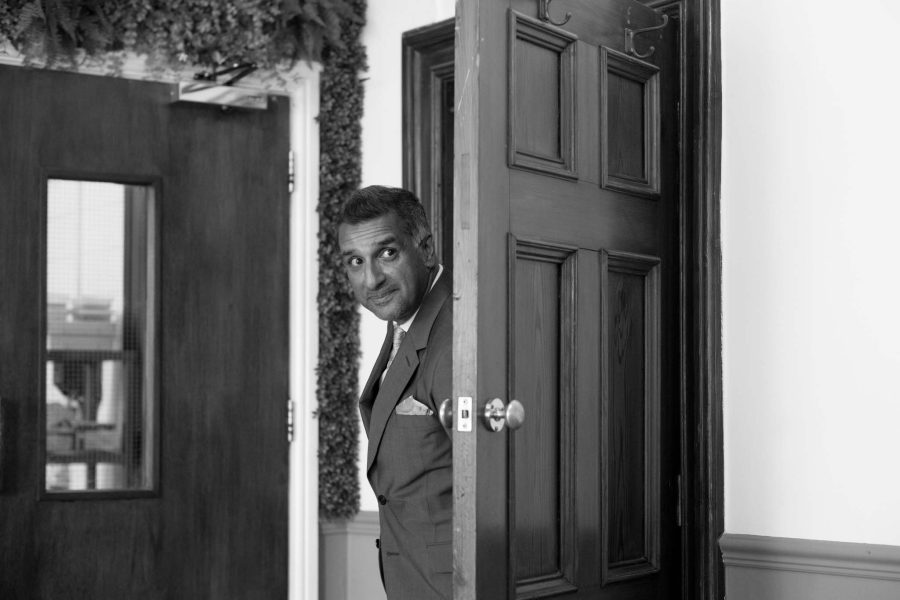 a groom is peeking through the door to see a bride