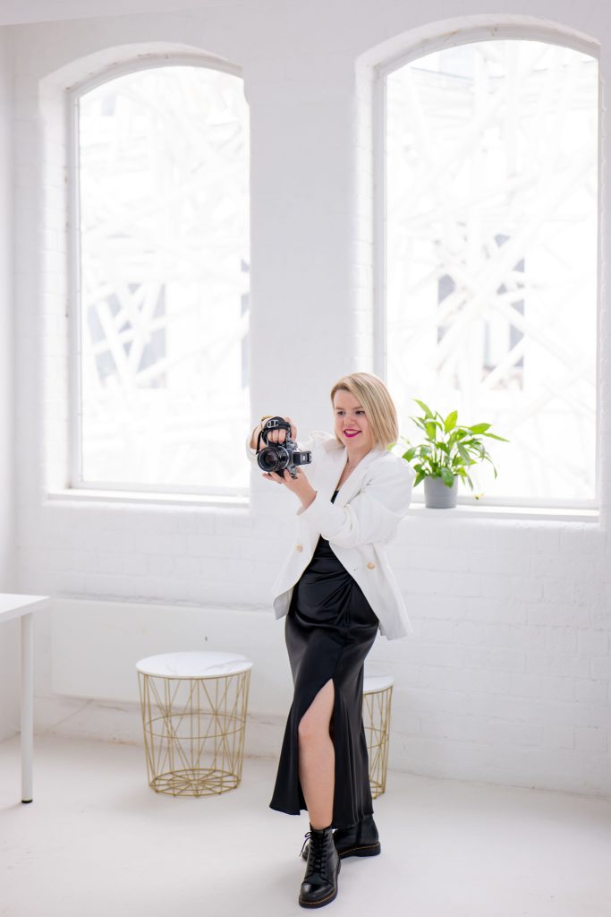 Behind the scenes of a professional photoshoot, a female photographer is taking a photo