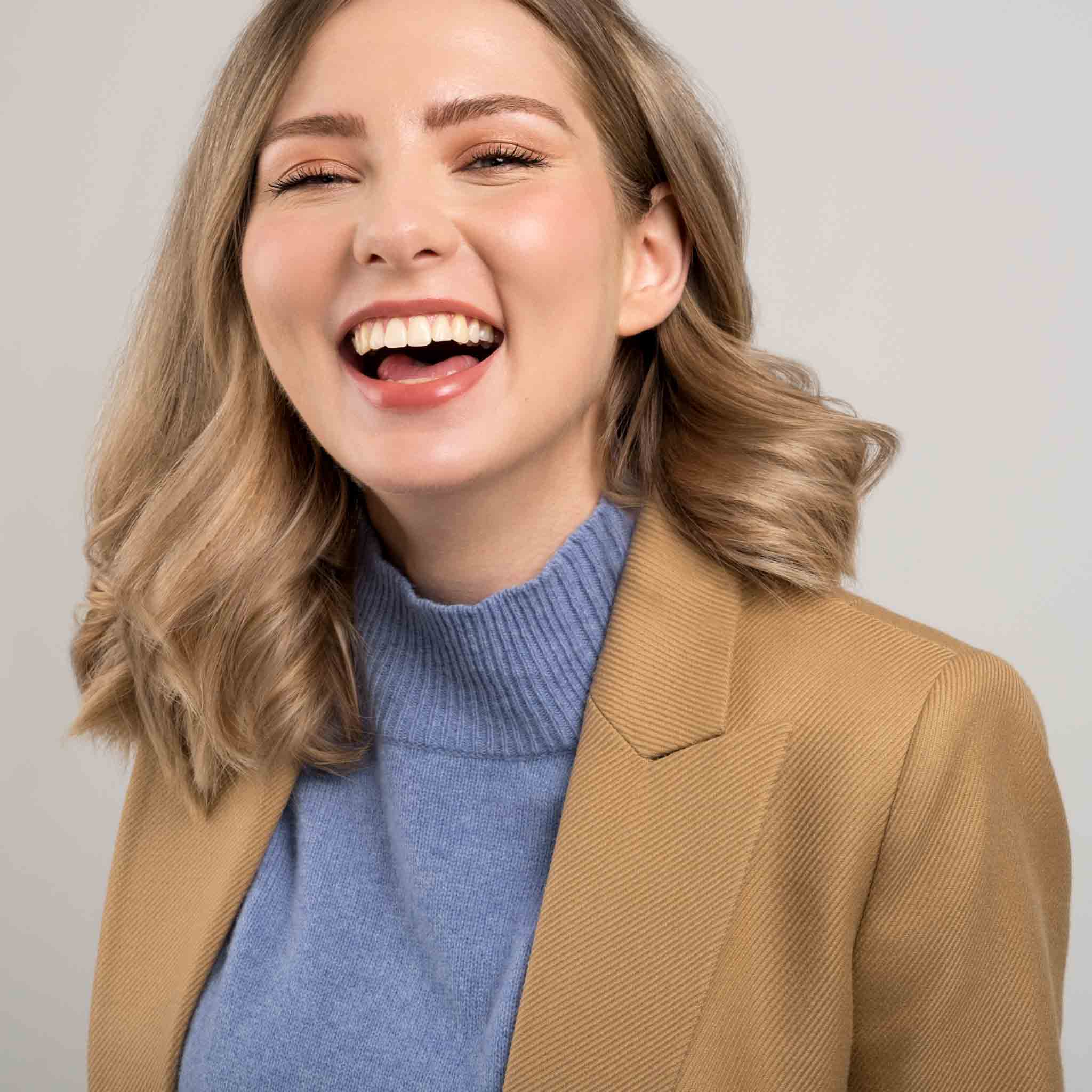 headshot photo of a woman laughing