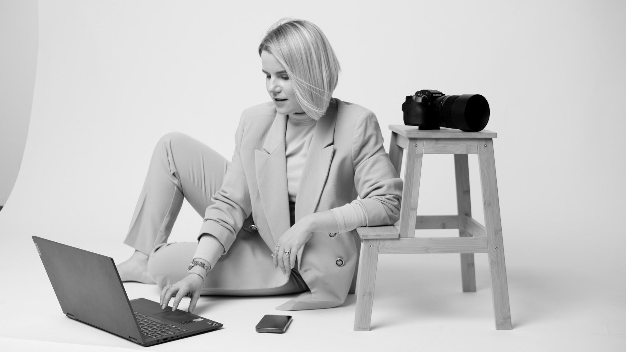 productivity when business is slow. blond female photographer working on a laptop