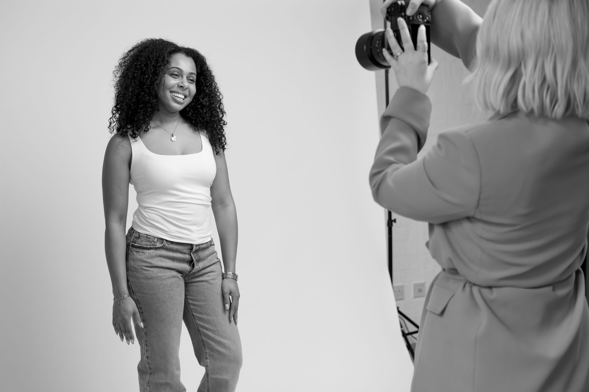 model portfolio photoshoot behind the scenes, a female model posing for the camera and laughing