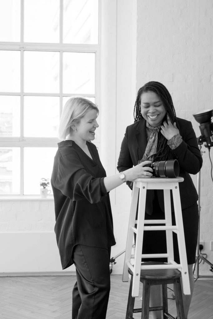 headshot photoshoot bts in Birmingham studio, a photographer and a client laughing reviewing the photos